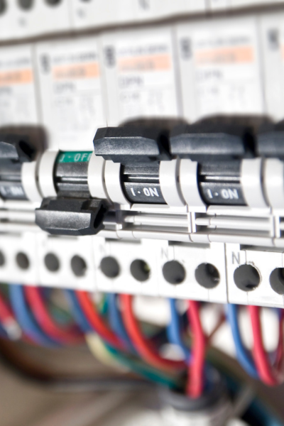 Close-up of circuit breakers in an electrical panel, showing detailed wiring and switches.