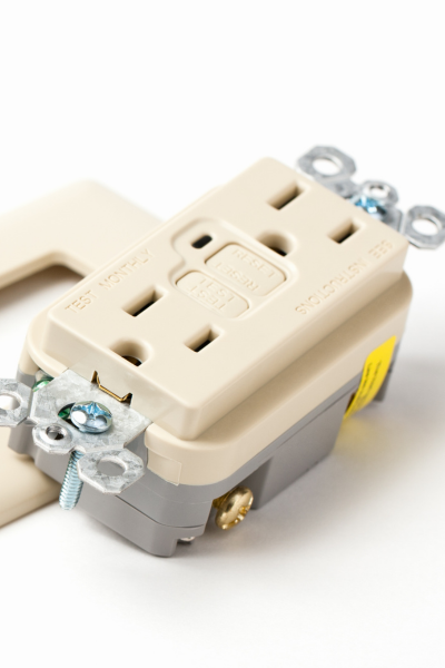 Close-up of a new electrical outlet ready for installation, showing detailed components and screws.