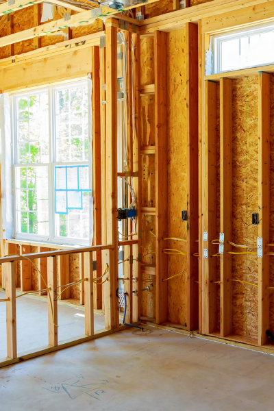 Interior of a room addition under construction with exposed wooden framing and new electrical wiring.