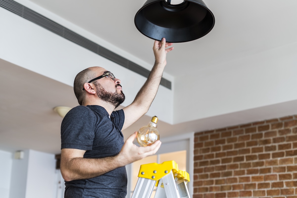 Man on a stair changing bulb